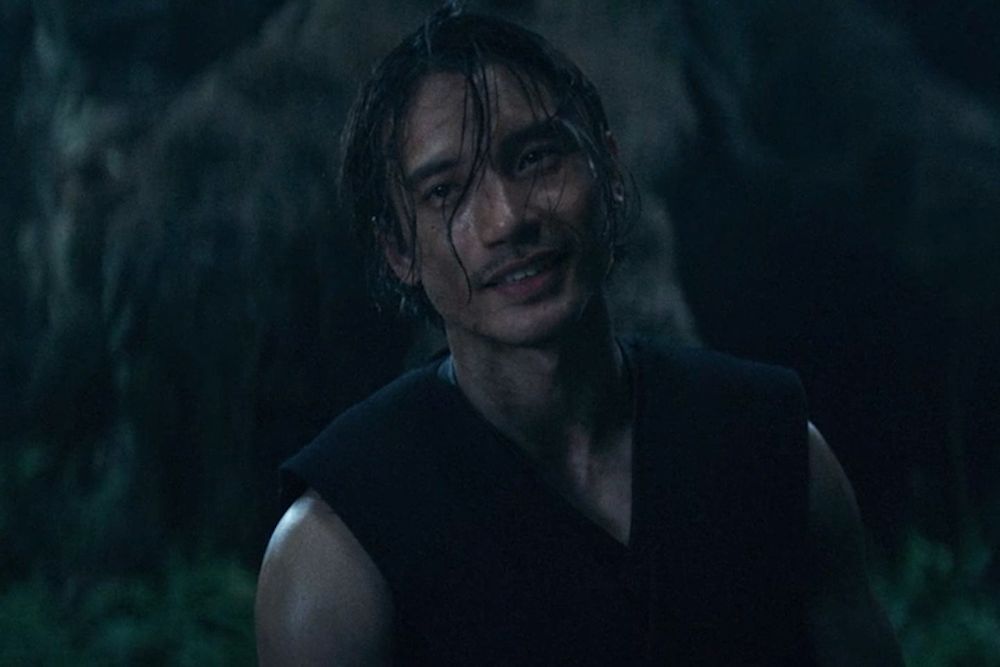 qimir looking at sol with a patronizing smile, tendrils falling in his face, head slightly tilted