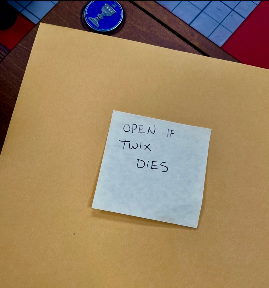 Image of a Manila envelope with a post-it that says “Open if Twix dies”
