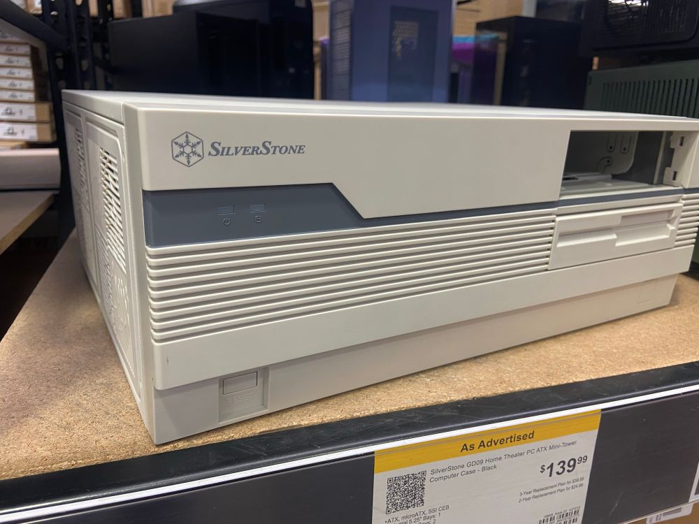 Photo of a horizontal PC chassis. It is beige and very 90’s looking, complete with a fake 3.5 floppy drive as an expansion bay cover.
