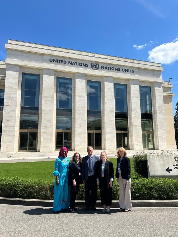 Five people stand outside of the United Nations building in Geneva.
