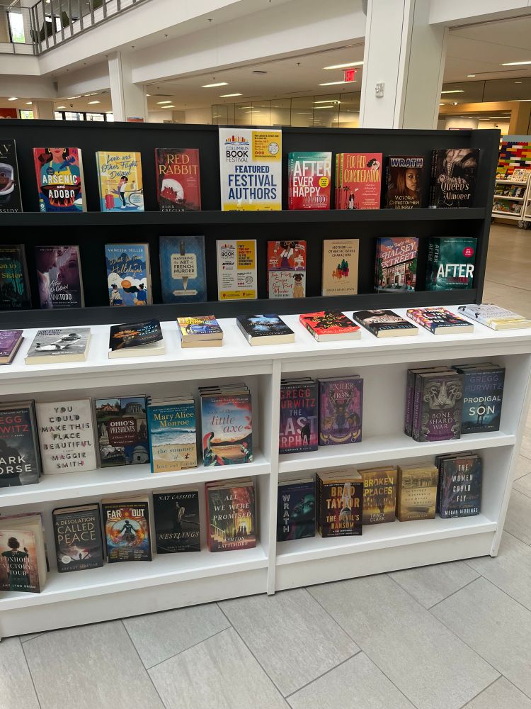 A shelf of books, labeled “Featured Festival Authors”. The Bone Share War is in the lower right 