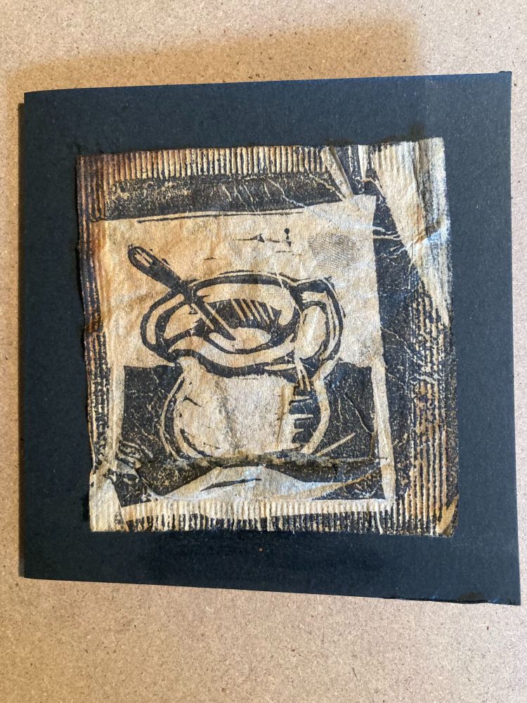 A small linoprint image printed onto a used teabag. The image shows a jug in black ink.