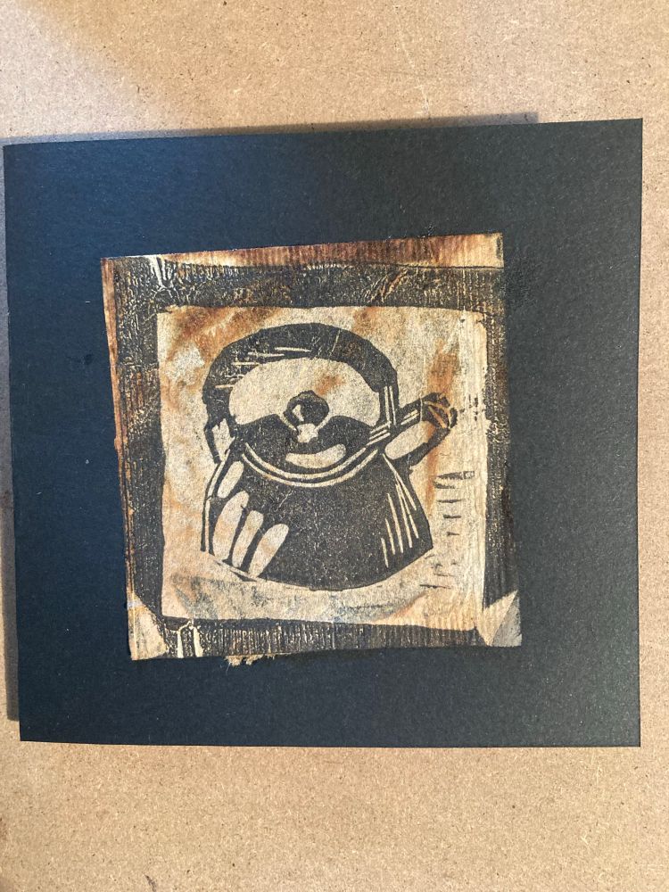 A small Lino print featuring a kettle printed onto a used teabag