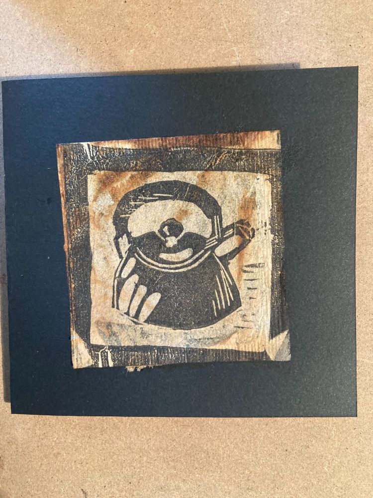 A small linoprint image of a kettle printed onto a used teabag