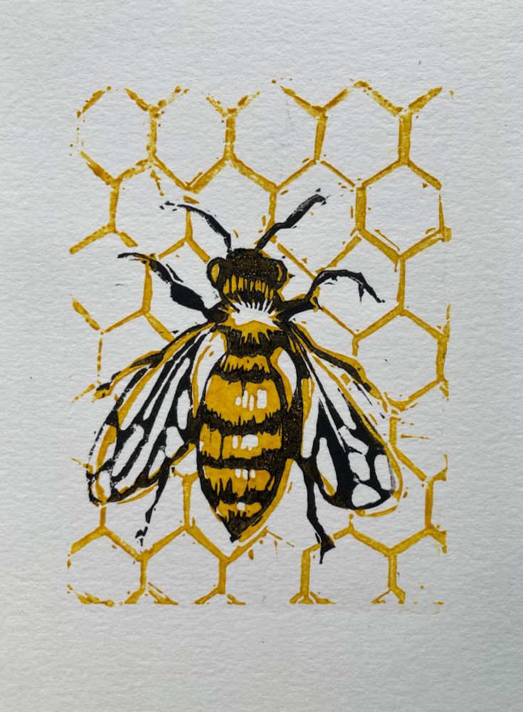 A lino cut print of a bee against honeycomb. The print is made with two layers in yellow and black