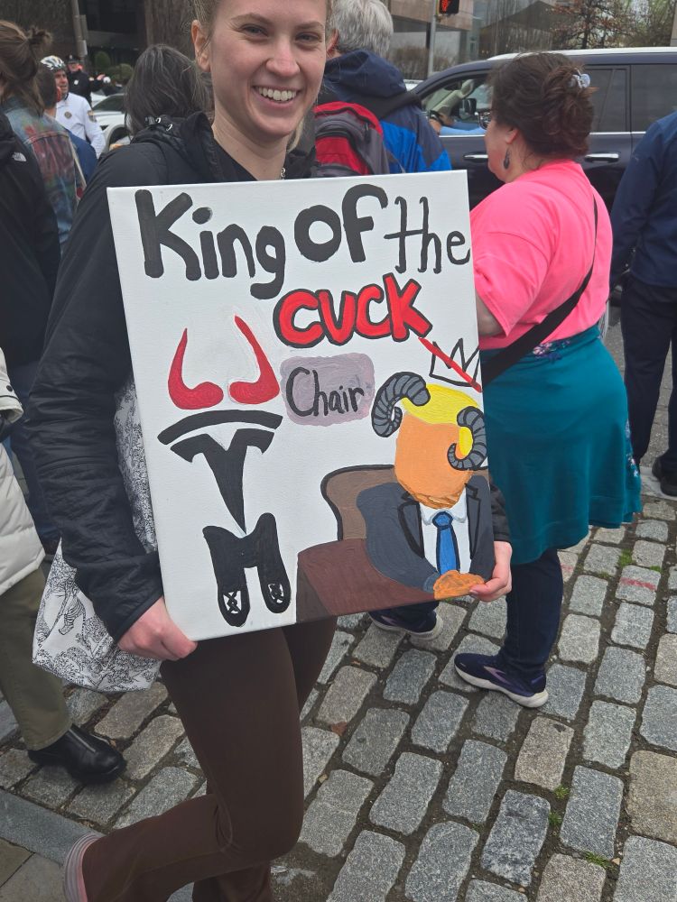 A sign reading King of the Cuck and trump with horns and other symbols