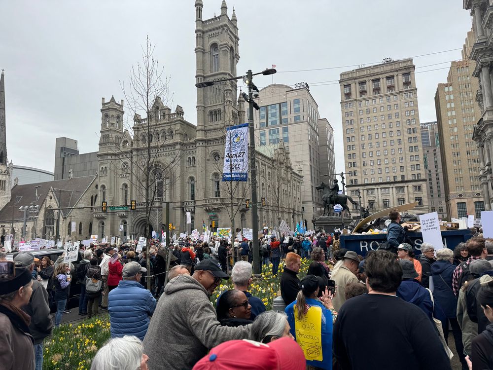 Protestors holding signs in front of Philadelphia City Hall 