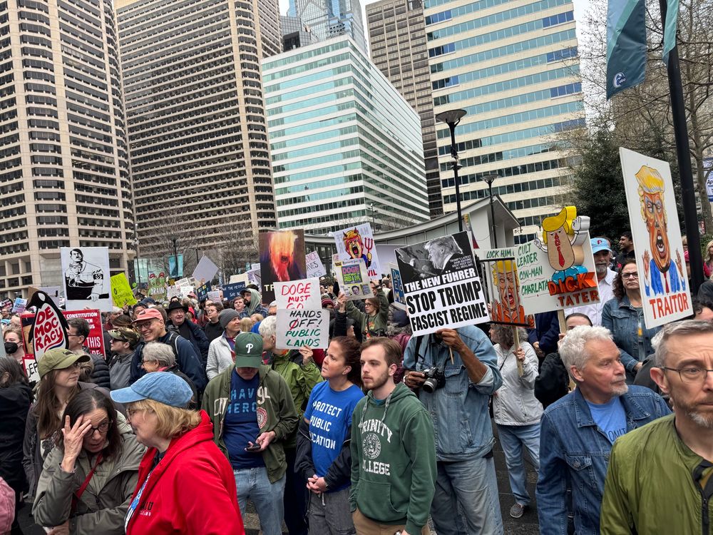 Protestors holding signs in front of Philadelphia City Hall 