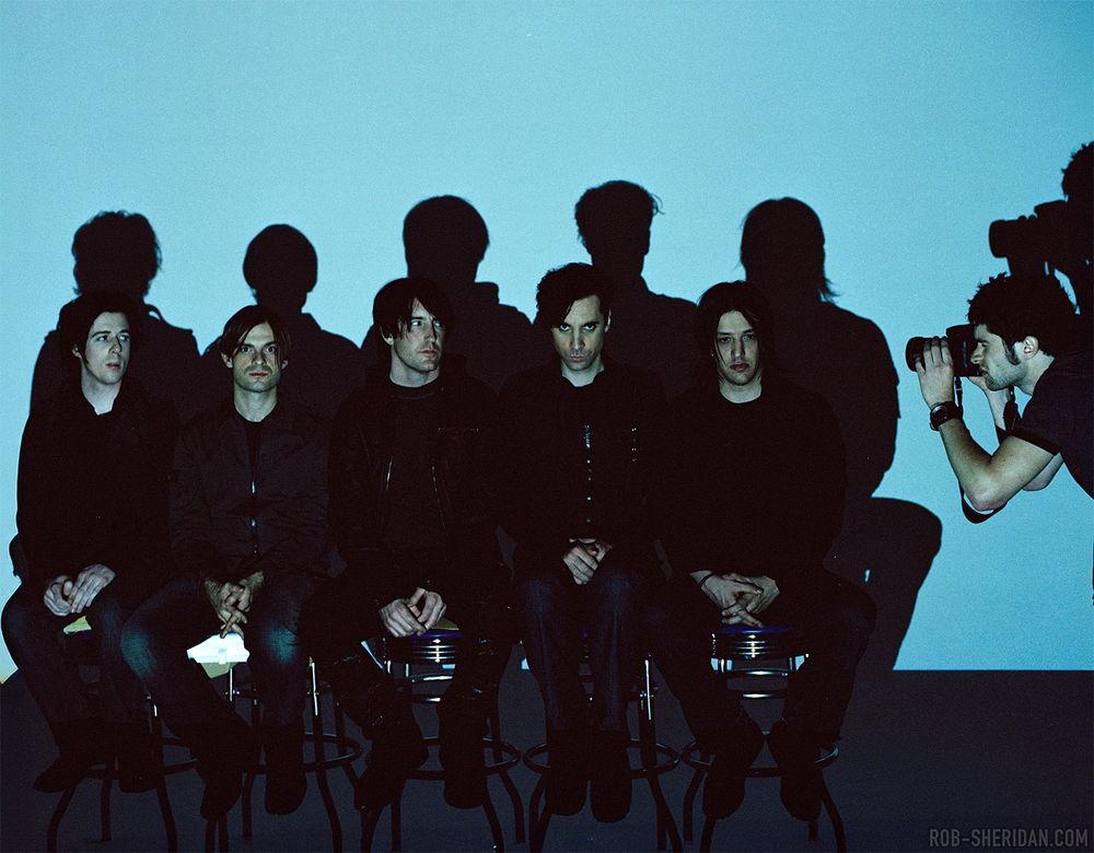 It is young me in 2005 pointing a camera at Nine Inch Nails, then composed of (L to R) Aaron North, Alessandro Cortini, Trent Reznor, Jerome Dillon, Jeordie White. They all have extremely 2005 haircuts. Photo by Tamar Levine.