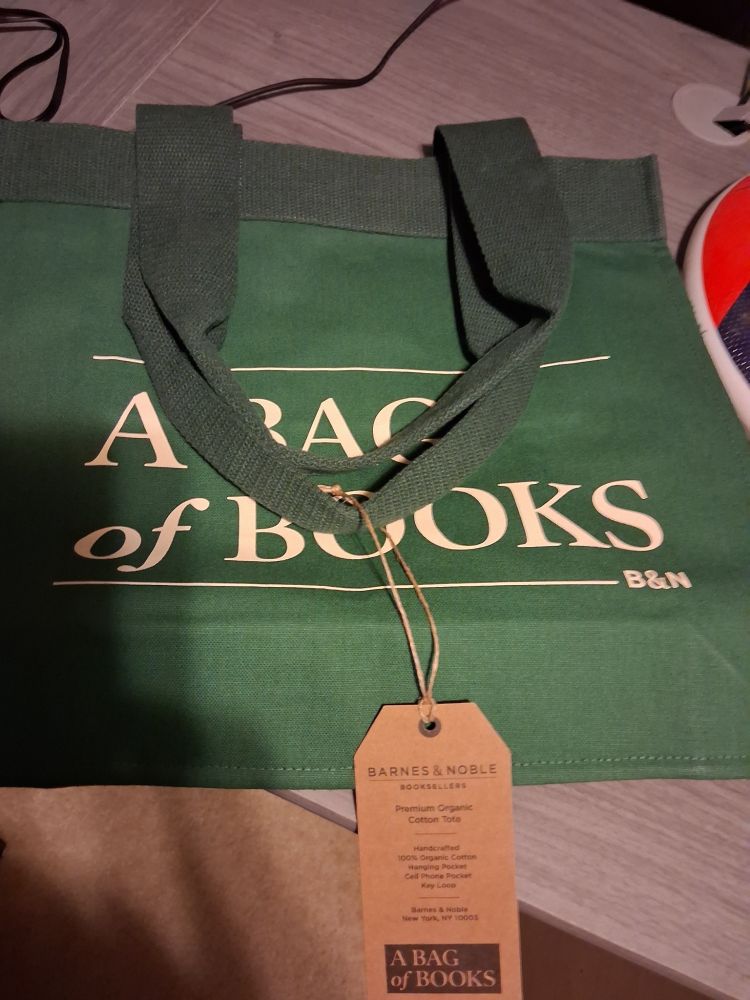 One of Barnes & Noble's cool tote bags!  This one is green, with the words "A BAG of BOOKS" written on it, with a brown information tag attached to the handle.