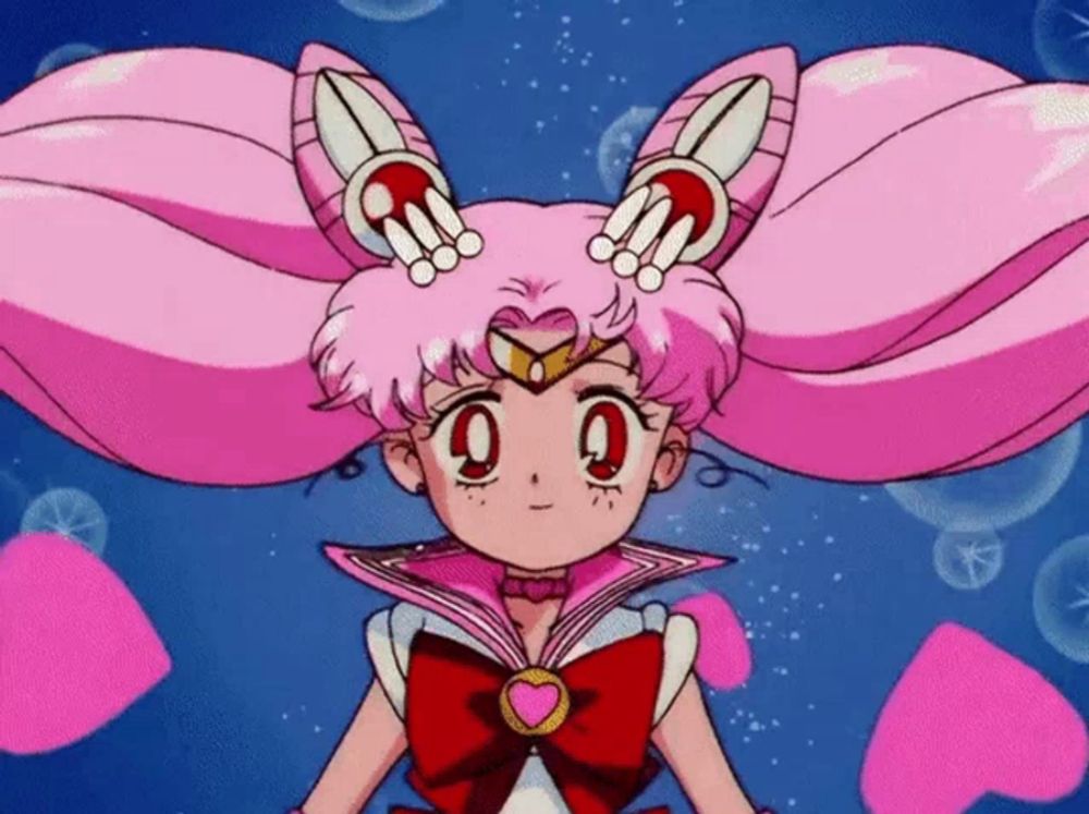 a little girl with pink hair is wearing a sailor moon uniform .