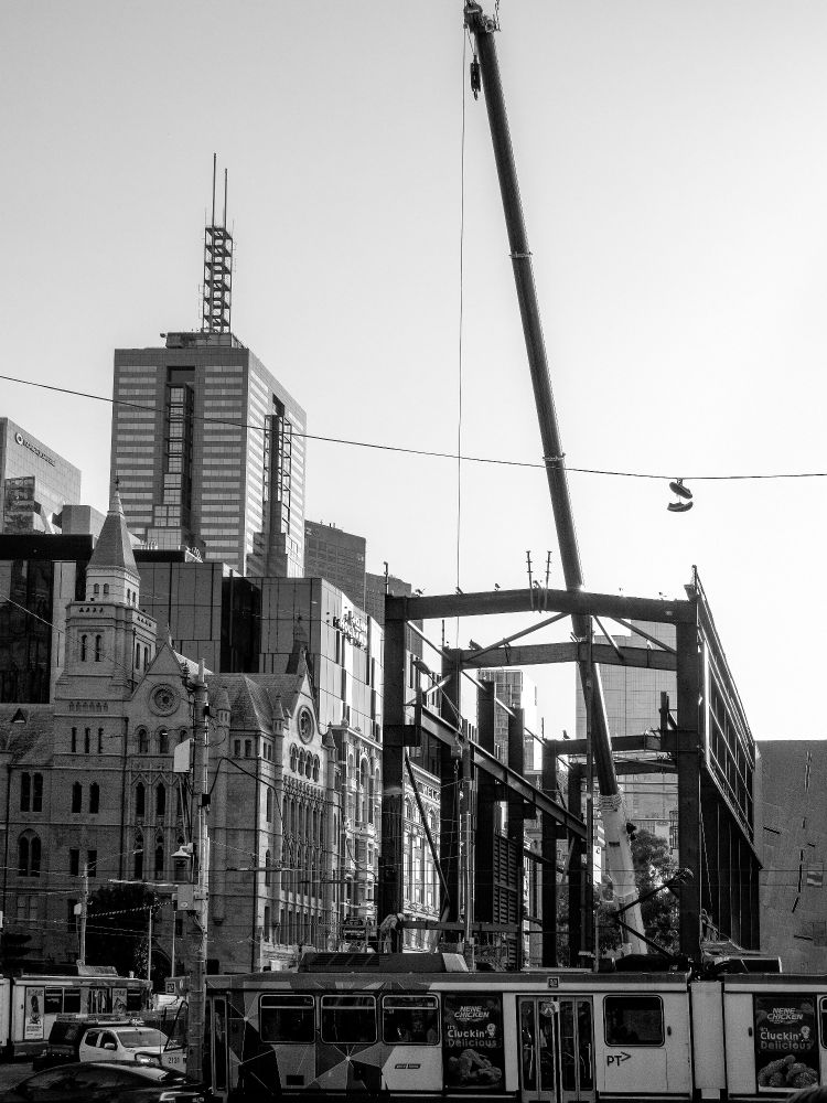 Shoes on a high wire against the backdrop of a new Metro Tunnel Station