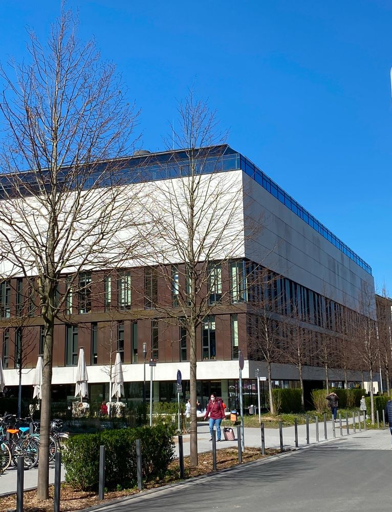 Research building Max Planck Institute for Biology of Ageing with a street and blue sky in the back. 