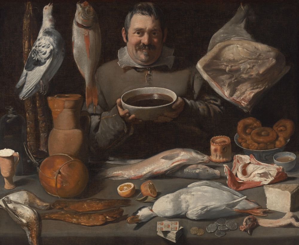 "Kitchen piece or Bodegón. The smiling chef stands with a large bowl of red wine behind a table laid out with all sorts of food: poultry, quail, a duck, a turkey, fish, mackerel, cheese, pies, rolls, sausages, hams, a pigeon, a red sea bream, and a pig's trotter. In front lies a deck of cards and some coins." https://www.rijksmuseum.nl/en/collection/object/Kitchen-Scene--3864a99eda3ad3900cfd4f947e6bb385?tab=data