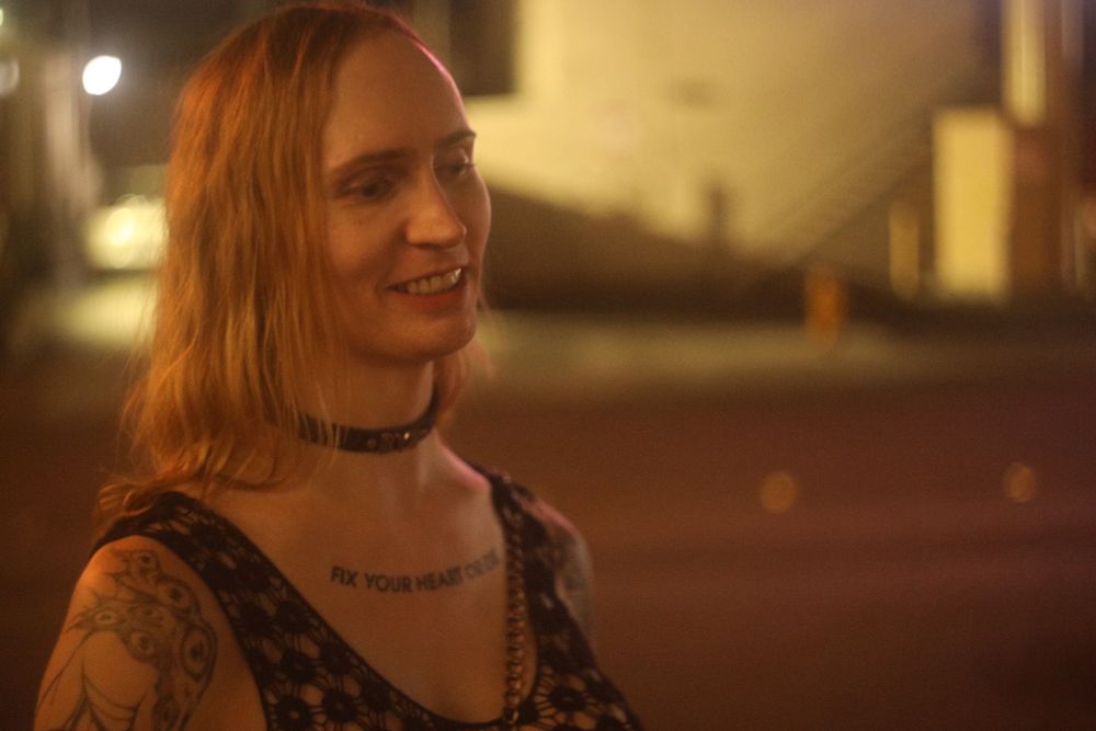 Jade wearing a semitransparent black top by a Vegas street at night
