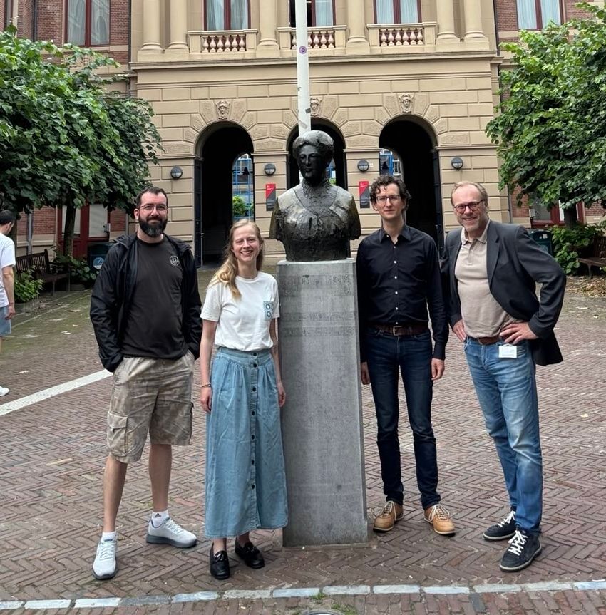 Marcello Seri, Thereza Langeler, Gerard Ritsema van Eck and Guido Visman posing next to the statue of Aletta Jacobs