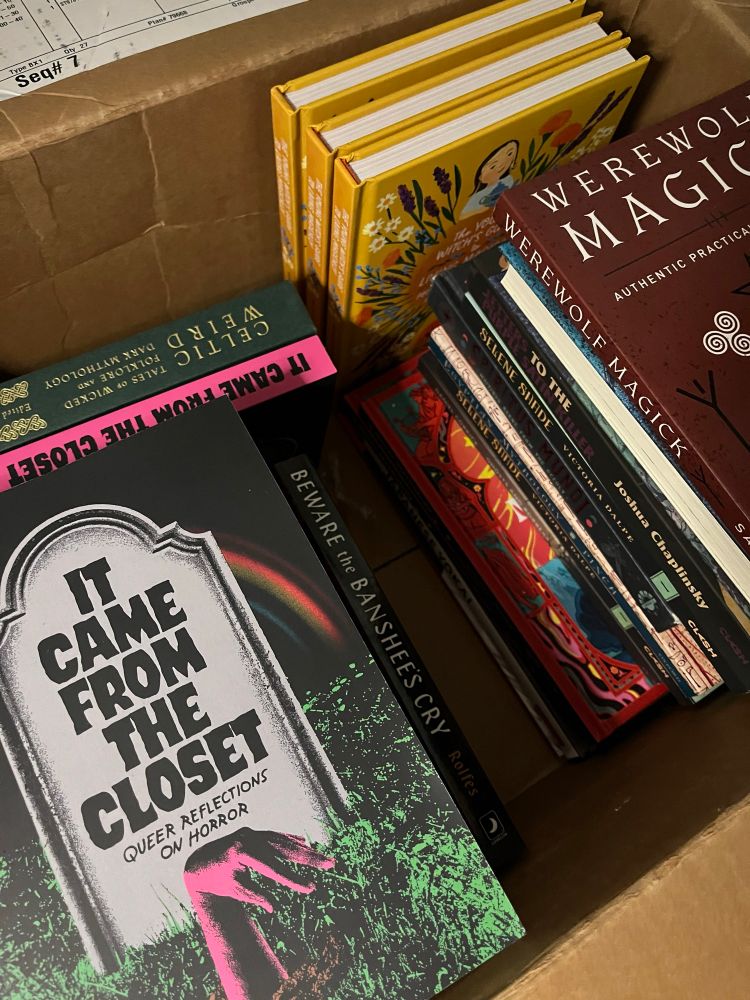 Cardboard box with books: It Came From the Closet, Werewolf Magick covers are visible 