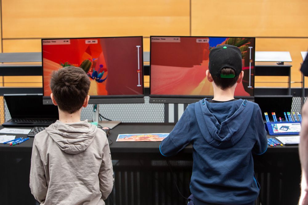 Two children play a game on a monitor at Drop in and play.