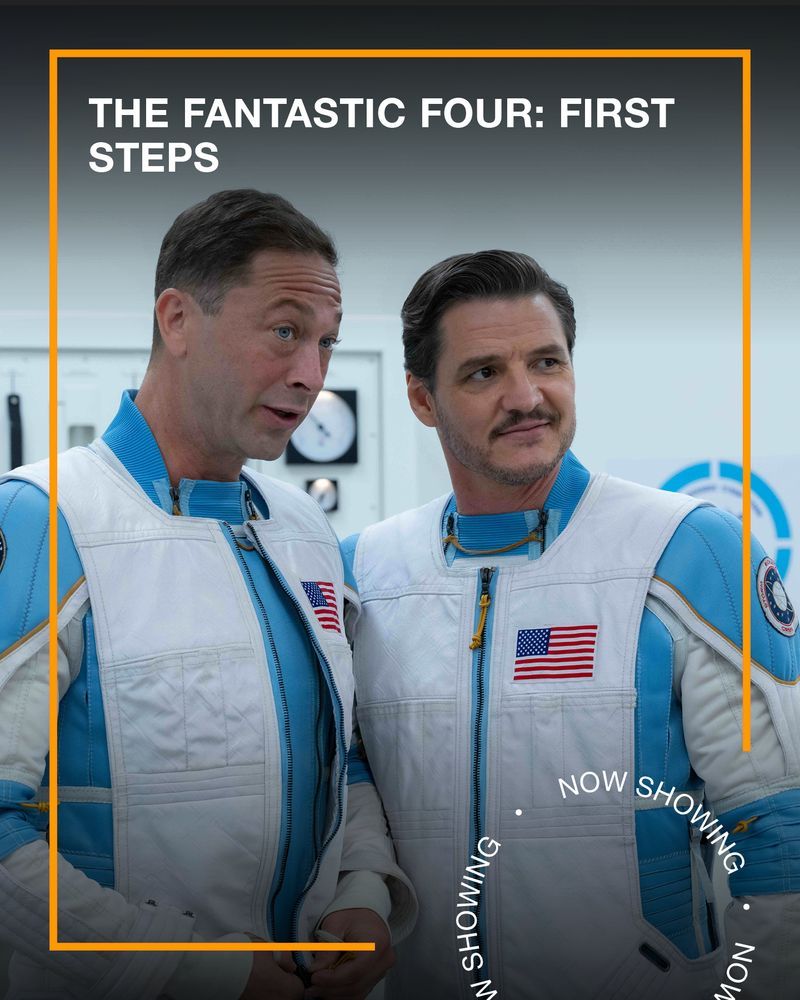 Two men wearing white and blue space suits stand next to each other smiling. Text - The Fantastic Four: First Steps, Now Showing.