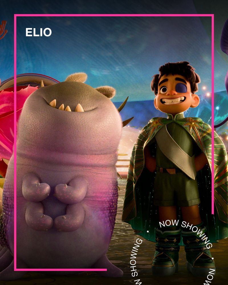 A little boy wearing a superhero costume stands next to a friendly-looking wormlike alien. Text - Elio, Now Showing.