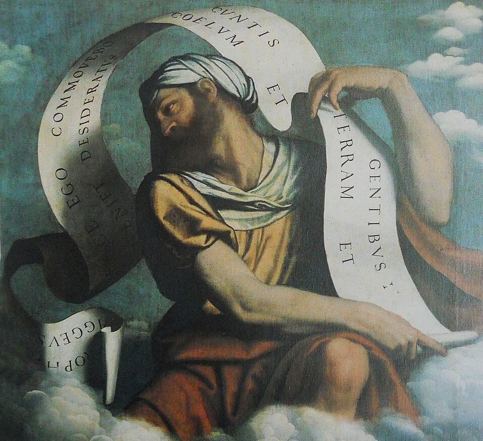 A painting of a young (or middle-aged) bearded man in a yellow tunic with a white headdress, sitting on a cloud. A large white scroll unfurls out of his hands, bearing a Latin verse from the Book of Haggai.