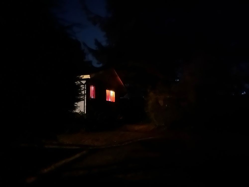 A darken photo of ops room taken from outside with glowing windows from the light inside 