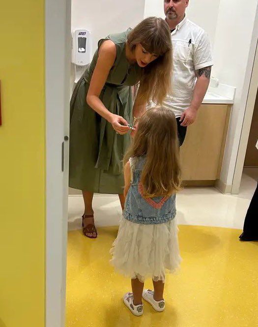 Taylor getting a friendship bracelet from a little girl at the children’s hospital
