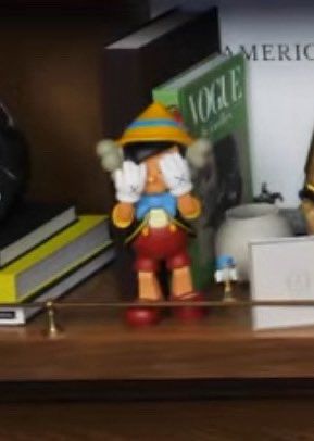 Small pinochio figurine in the back of the new heights podcast