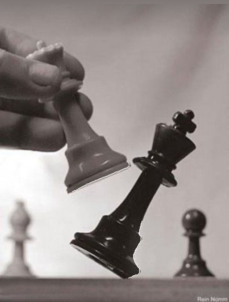 A black and white photograph of a queen taking a king in chess 
