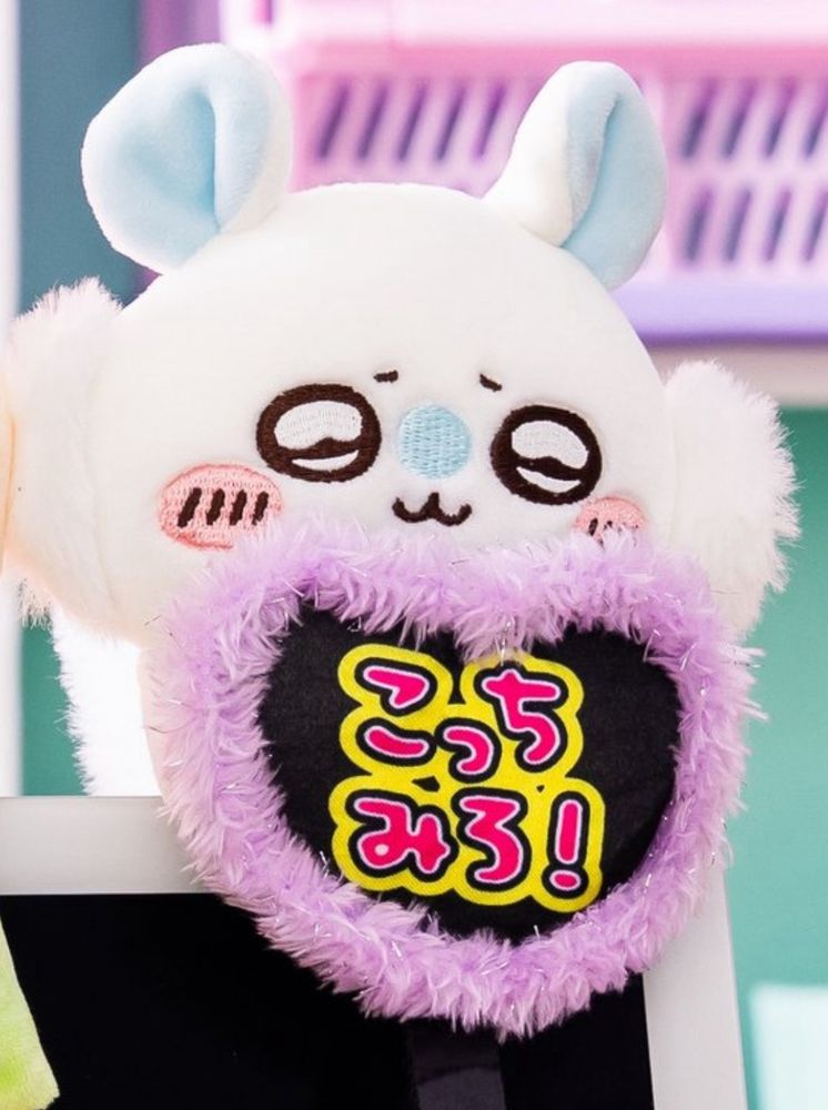 cutie momonga plushie holding a heart that says kocchi miro (look here)