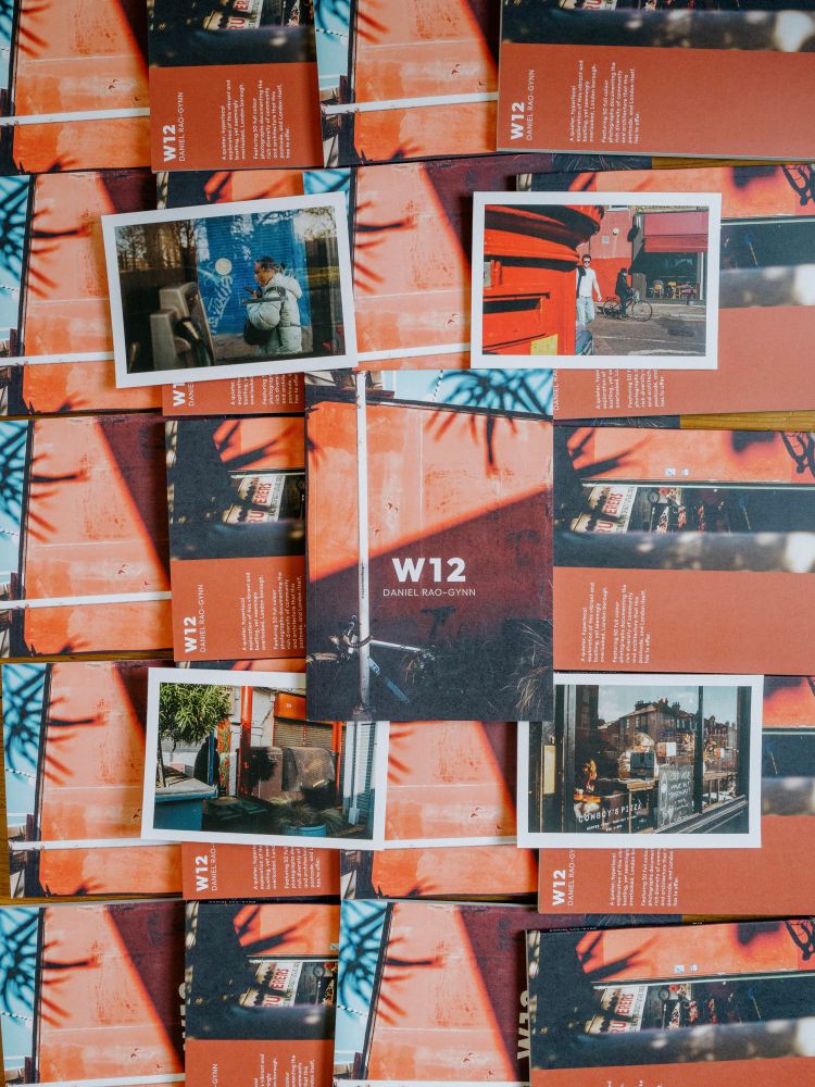 Shows the front cover of the ‘W12’ zine on a stacked background of the same zine