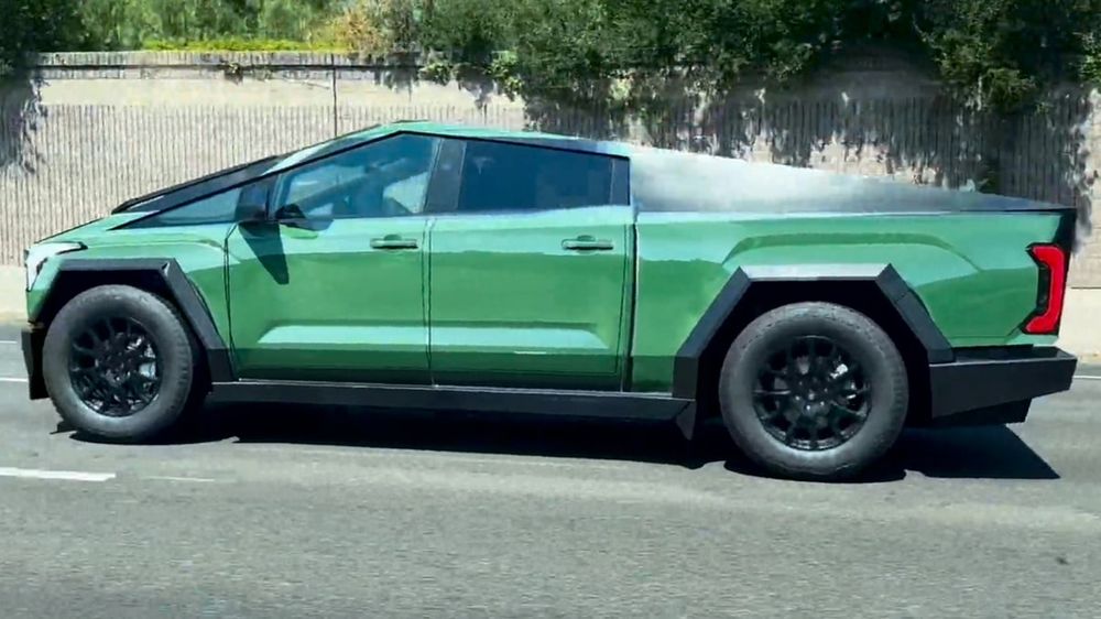 A Tesla Cybertruck with a vinyl wrap which disguises it to look like a green Ford F-150 pickup