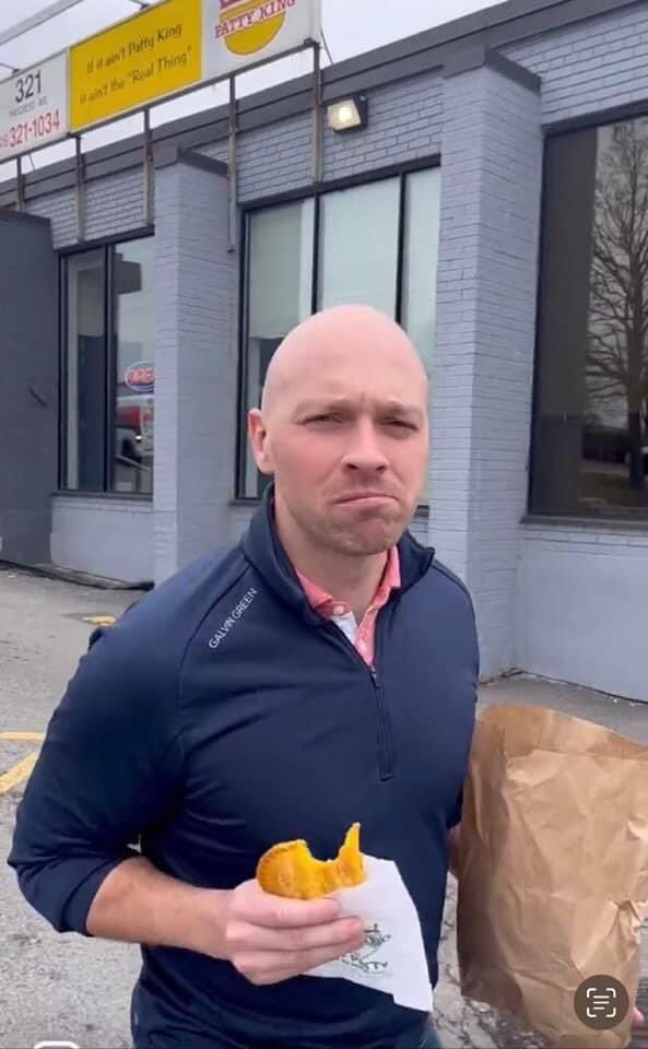 A photo of Toronto councillor Brad Bradford (widely disliked by his own constituents) when he was running for mayor, doing what he could to impress the city's diverse population - by eating patties