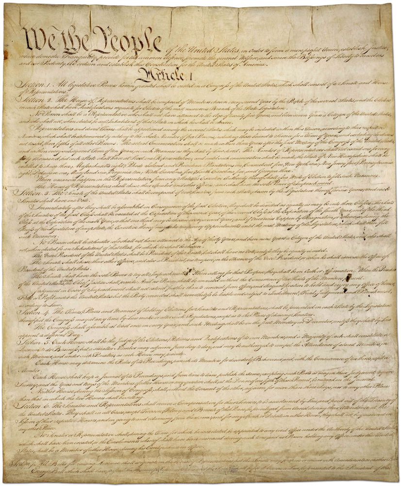 The US constitution, written almost entirely in cursive on yellowy parchment.