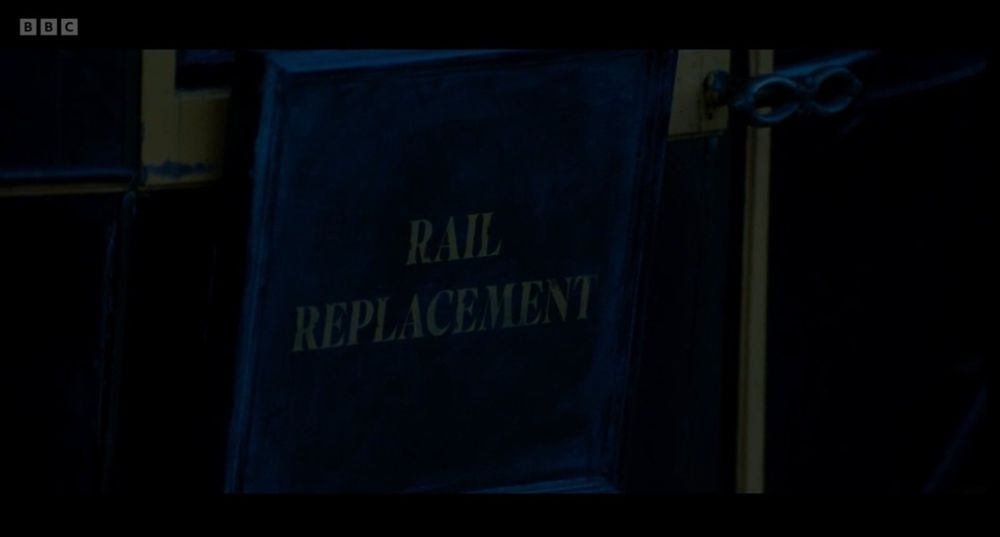 Dark sign on the side of a carriage which says 'rail replacement'