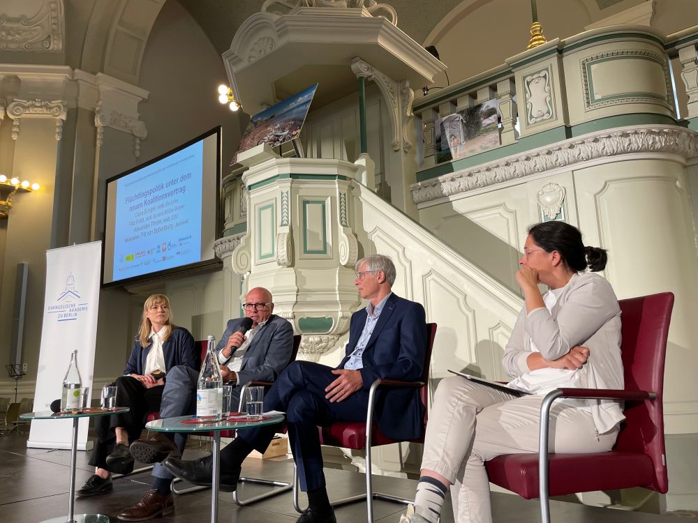 Podium vor Kirchenkanzel, darauf von links nach rechts: Clara Bünger (Die Linke), Alexander Throm (CDU), Moderator Pitt von Bebenburg (Frankfurter Rundschau) und Filiz Polat (Bündnis 90/Die Grünen).