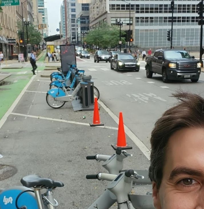 Selfie showing me and cones blocking area next to densified Divvy station at Washington and Franklin in the Loop. 