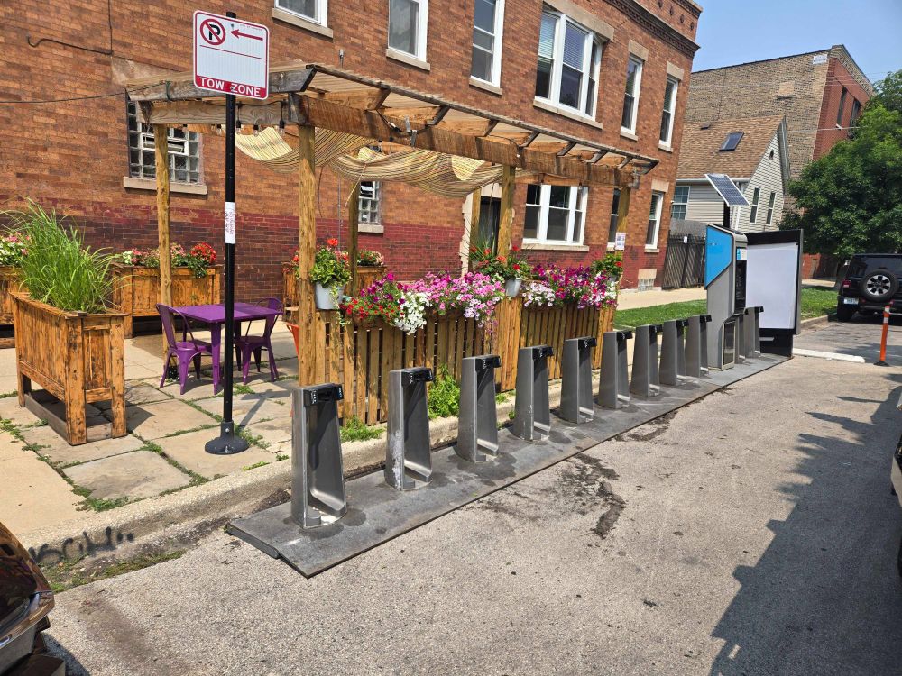 New Divvy station placed on street next to an outdoor dining area with a gazebo on the adjacent sidewalk