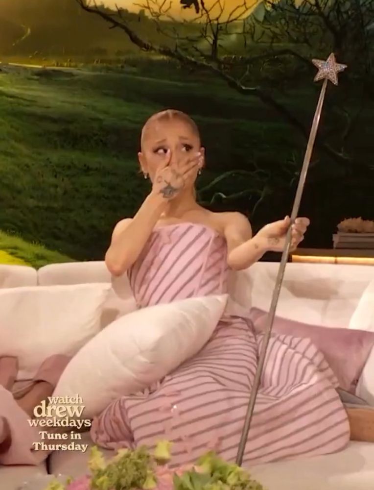 Ariana Grande in shock, holding the original Glinda prop from ‘The Wizard of Oz.’