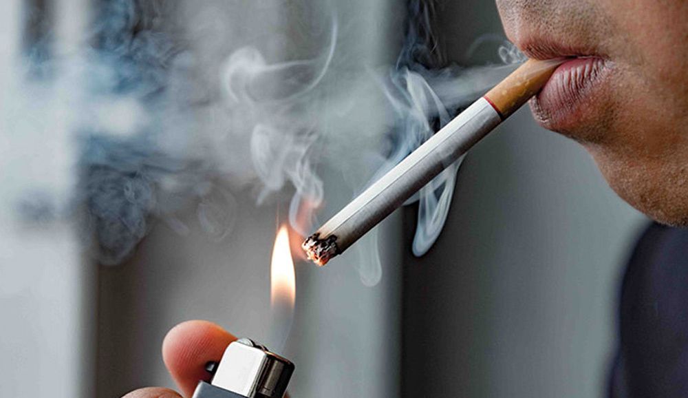 Stock image of an anonymous person lighting a cigarette.