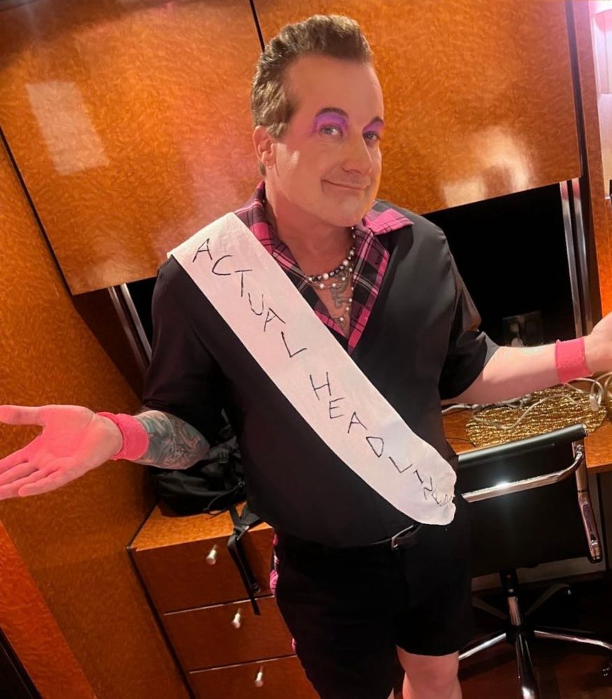 Tré Cool wearing a sash that says “actual headliner.”