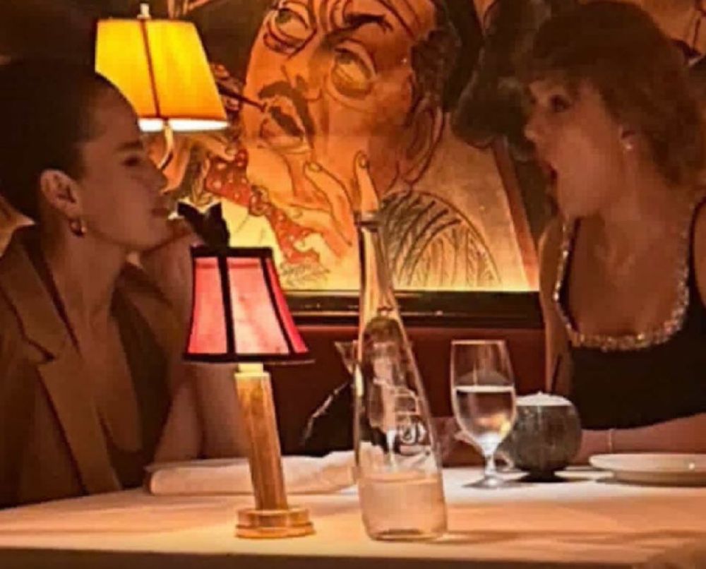 Photo of Selena Gomez and a gasping Taylor Swift at dinner. 