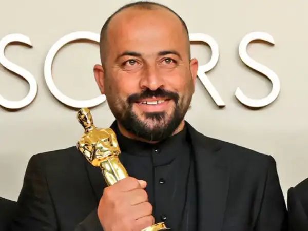 Hamdan Ballal holding his Oscar award.