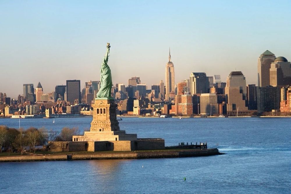 Photo of New York City featuring buildings and the Statue of Liberty. 