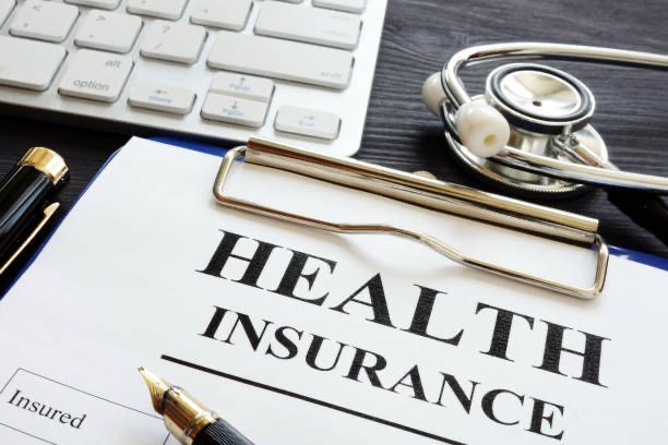 Photo of a desk with a “Health Insurance” document. 