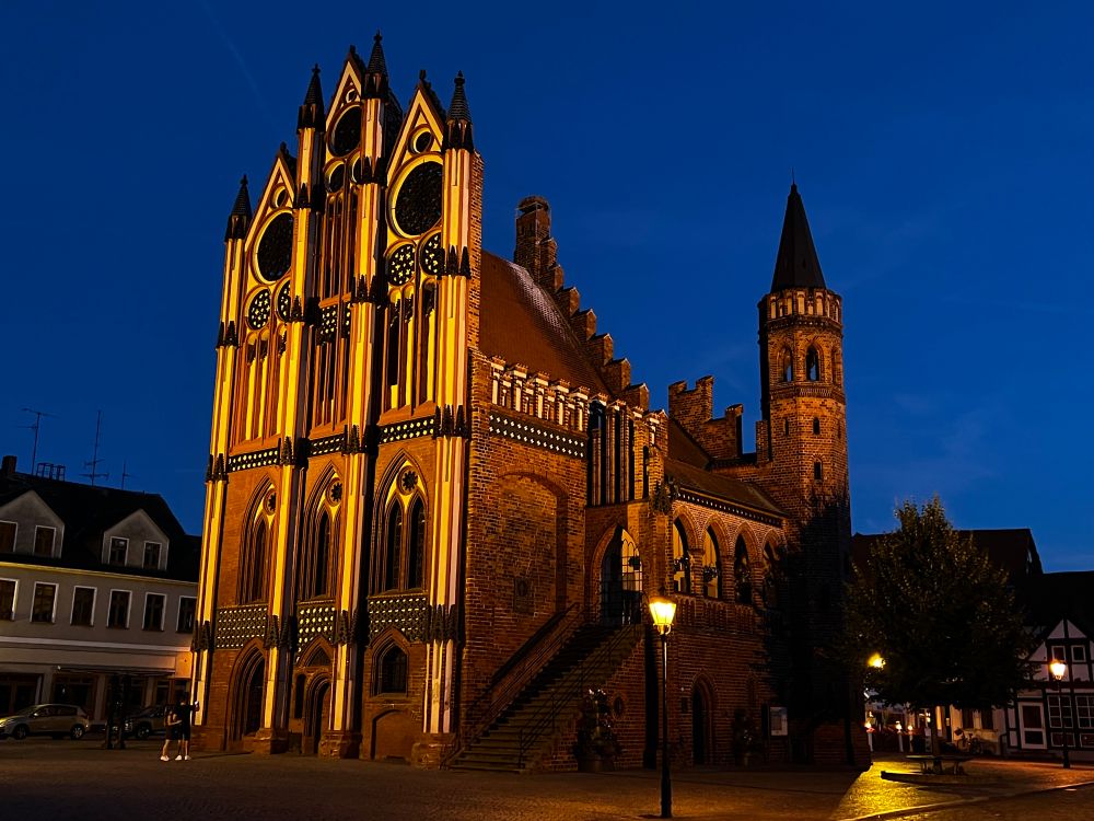 Eine Kirche rötlich angestrahlt zur blauen Stunde 