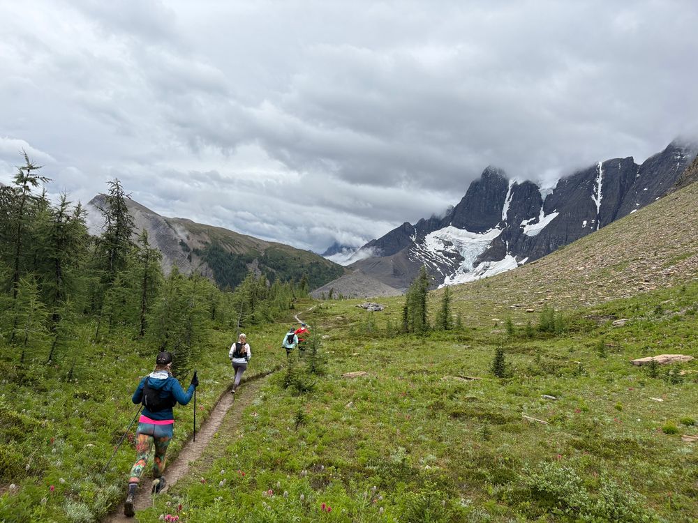 Runners on curved trail beside Rockwall in the Canadian Rockies