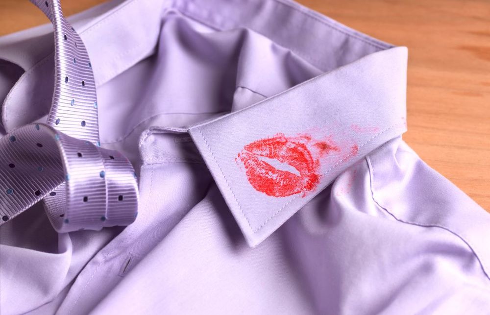 Red lipstick kiss marks on a lilac dress shirt collar.