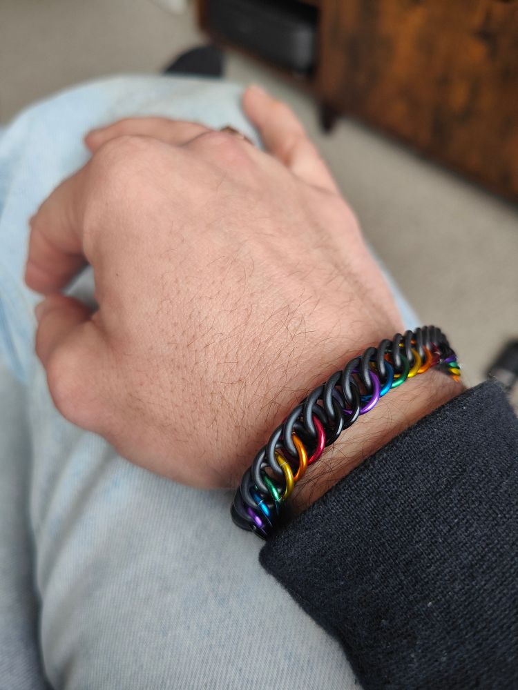 A black and rainbow chainmail bracelet on my wrist