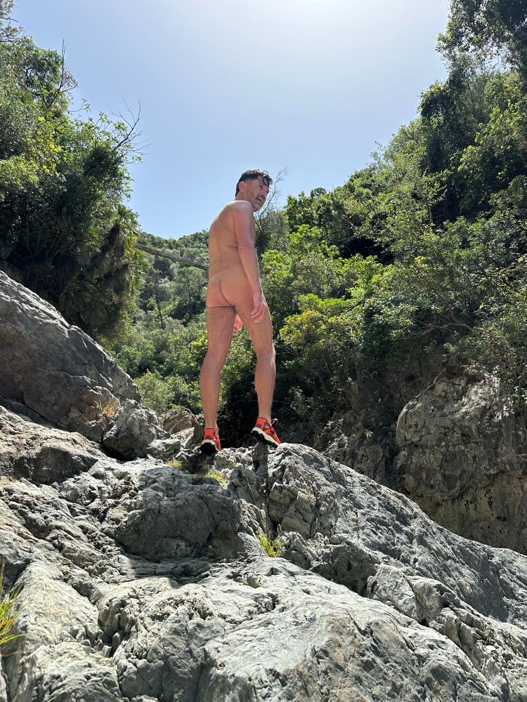 Naked guy on a rock in nature